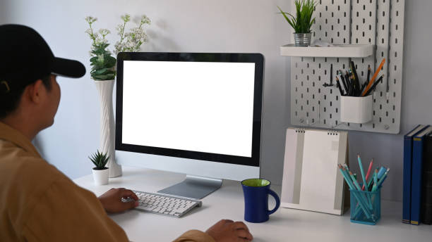 istock Young man freelancer sitting at modern workplace and working online with computer. 1303613891