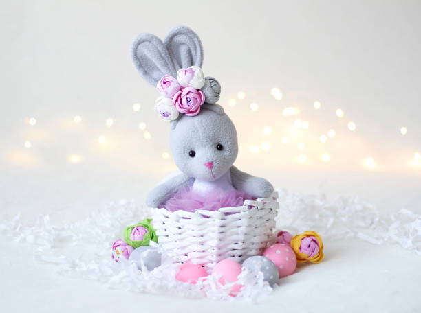 istock Eggs and a gray rabbit in a basket. Postcard for the Easter holiday. 1303617153