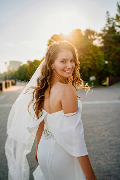 istock solar glare. bride with long curls in a white elegant dress 1303617456