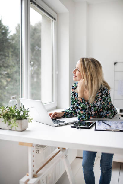 istock Businesswoman working at ergonomic standing workstation. 1303619978