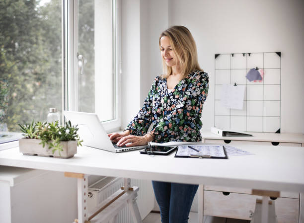 Businesswoman working at ergonomic standing workstation.