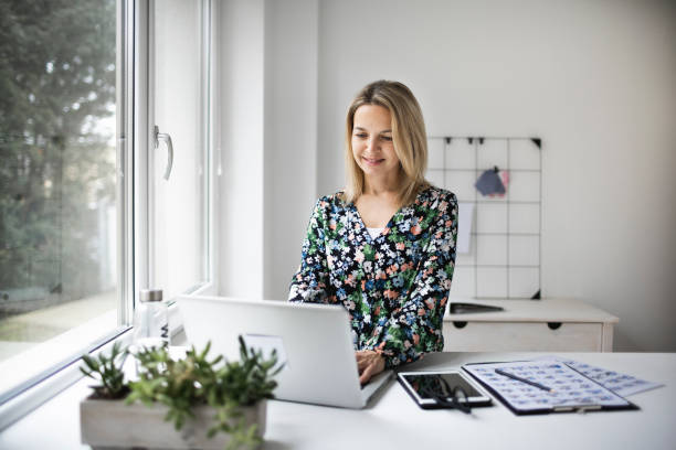 istock Businesswoman working at ergonomic standing workstation. 1303620076