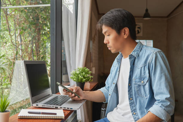 istock Young Asian Casual Businessman Using Smartphone and Laptop 1303621248