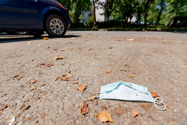 istock Disposable dirty face mask on ground, waste environmental pollution 1303624642