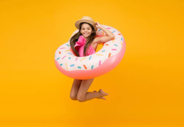 istock completely happy. child with inflatable rubber circle having fun on beach. freedom and childhood happiness. finally summer vacation. small girl jump. swimming pool at vacation. donut pool party 1303625201