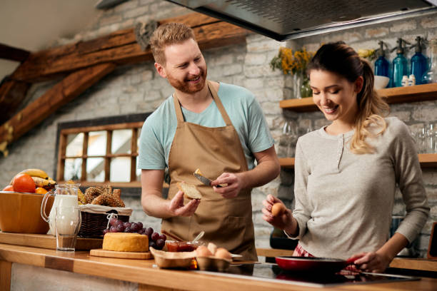 istock Happy couple preparing breakfast together in the kitchen. 1303625262