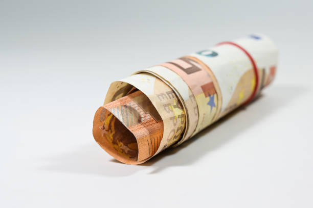 istock Some 50 euro notes rolled up into a small roll on a light background with copy space, selected focus 1303628889