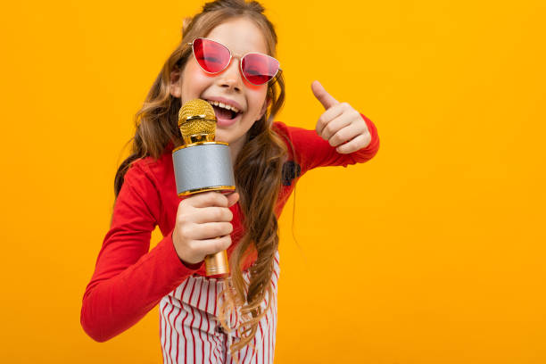 istock pretty presenter with microphone shows class on yellow background close-up with copy space 1303630592