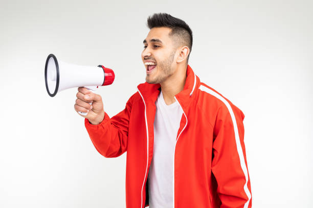 istock brutal man in a sports uniform with a loudspeaker on a white studio background 1303630958
