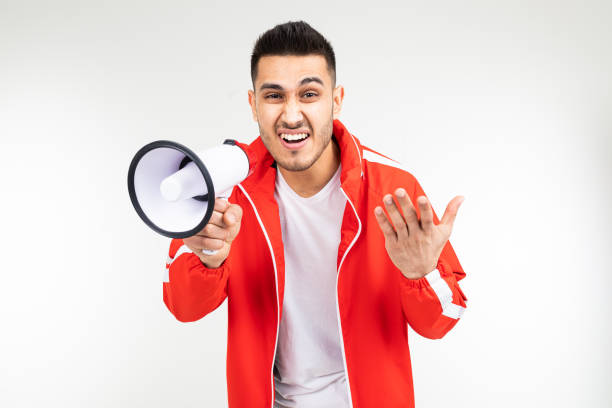 istock brutal man in a sports uniform with a loudspeaker on a white studio background 1303630987