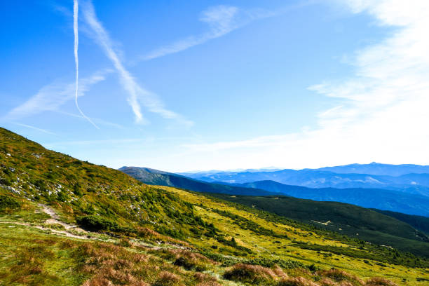 View while climbing Mount Hoverla. View of the mountain, forests and clouds. Ukrainian Carpathians. Blue sky. Nature landscape