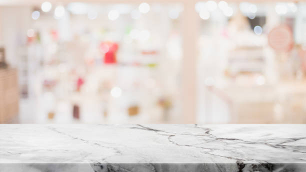 istock Empty white marble stone table top and blur glass window interior shopping mall banner mock up abstract background - can used for display or montage your products. 1303633736