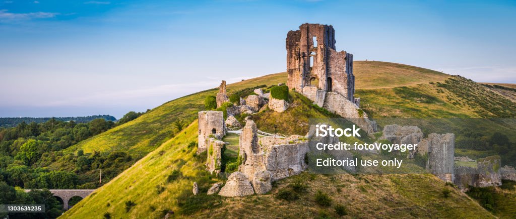 Medieval ruins Corfe Castle sunset panorama Isle Purbeck Dorset UK The iconic medieval ruins of Corfe Castle built high a hill in the idyllic Purbeck countryside of Dorset, UK. Castle Stock Photo