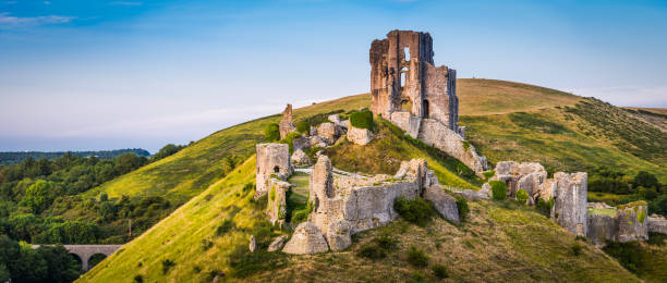 Medieval ruins Corfe Castle sunset panorama Isle Purbeck Dorset UK The iconic medieval ruins of Corfe Castle built high a hill in the idyllic Purbeck countryside of Dorset, UK. dorset england photos stock pictures, royalty-free photos & images