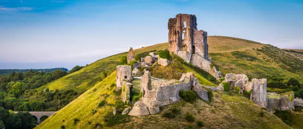 The iconic medieval ruins of Corfe Castle built high a hill in the idyllic Purbeck countryside of Dorset, UK.