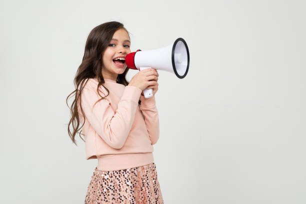 istock girl with a megaphone in hand sideways on a white studio background with copy space 1303634645