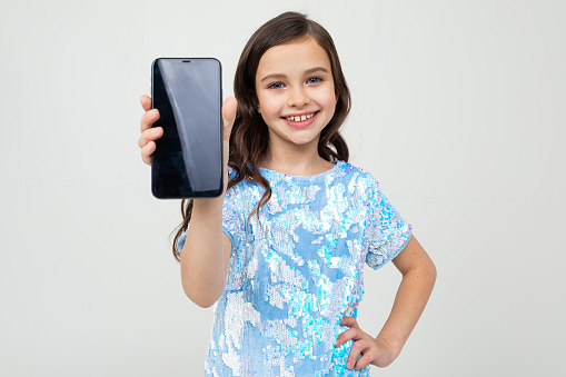 smiling girl shows a blank screen with a mockup on a white background.