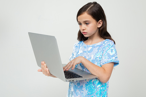 charming teen girl made an order for an educational course via the Internet using a laptop on a white background.