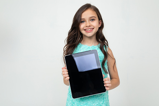 smiling girl holding a tablet with a template for inserting a web page or advertisement on a white background.