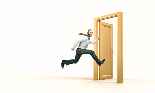 smiling businessman runs and enters a gold door. success concept.