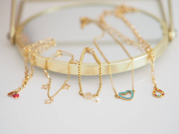 Gold bracelets and necklaces on a mirror stock photo