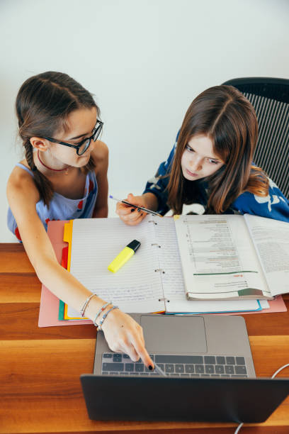 istock Siblings helping each other on homework at home 1303636127