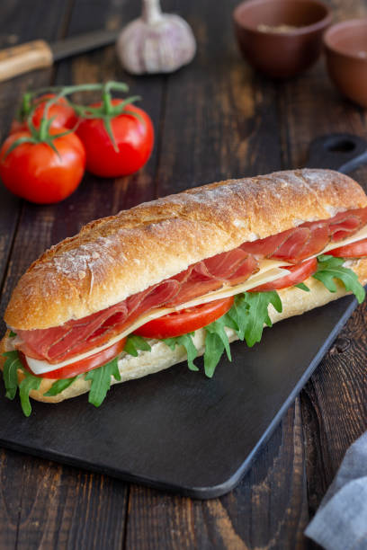 istock Sandwich with prosciutto, tomatoes, arugula and cheese. Healthy eating. Diet. 1303637995