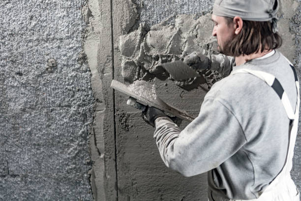 istock Real construction worker working on a wall inside the new house. 1303638030