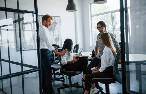 istock Active conversation. Young business people in formal clothes working in the office 1303638606
