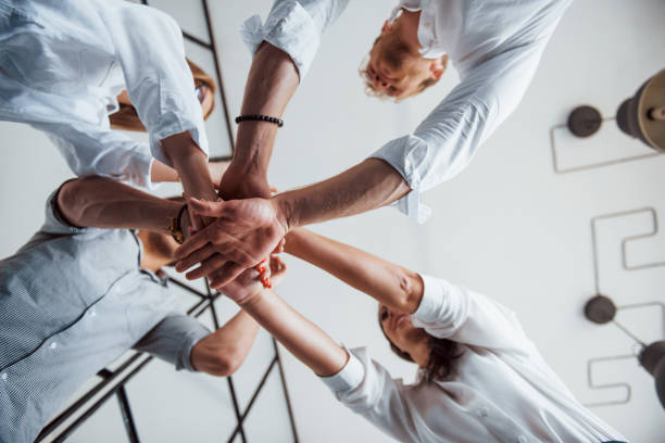 istock View from below. Successful business people putting their hands together 1303640473