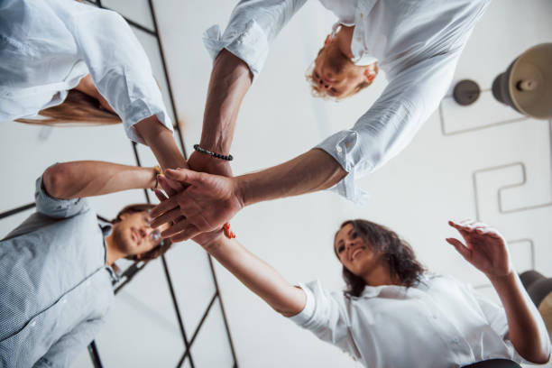 istock View from below. Successful business people putting their hands together 1303640556