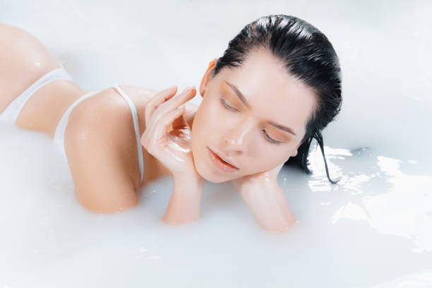 istock Close up female model in the milk bath with soft white glowing. Copyspace for advertising. Beauty, fashion, style, bodycare concept. 1303640745