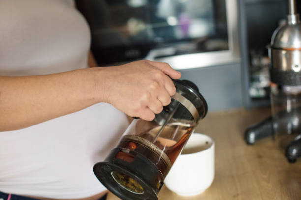 istock Pregnant woman in kitchen pour coffee. 1303640761