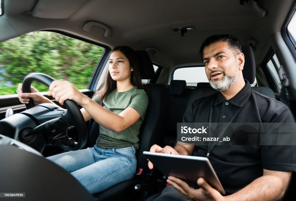 Driver training exam. Young girl taking lessons for driving on the road in Auckland, New Zealand. Driving Stock Photo