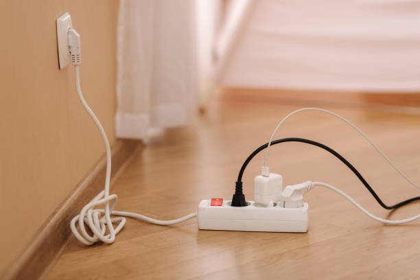 istock White cable connector for overloaded power boards at home. Close up focus at a plug foreground 1303641962