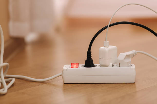 istock White cable connector for overloaded power boards at home. Close up focus at a plug foreground 1303641966