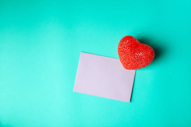 istock Blank pink greeting card with red heart on cyan background 1303643770