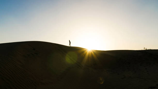 istock Silhouette of a man walking on a sand dune, Jaisalmer desert 1303644604