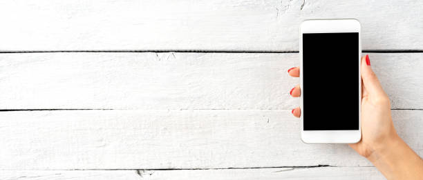 istock Woman’s hands showing smart phone with blank screen. Banner 1303646185