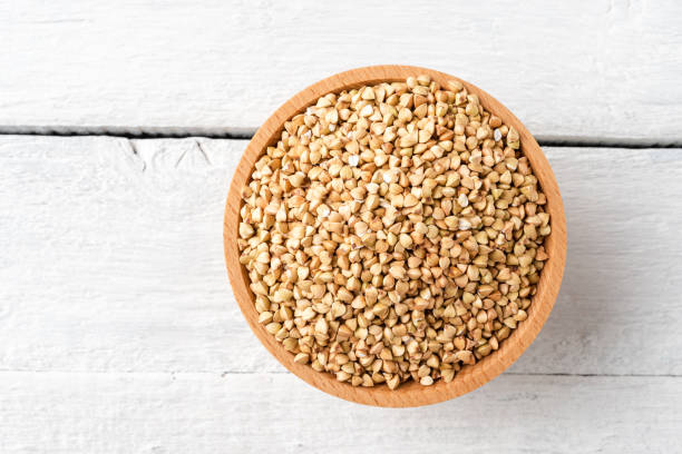 istock Buckwheat grains in bowl on rustic wooden table. Top view 1303646253
