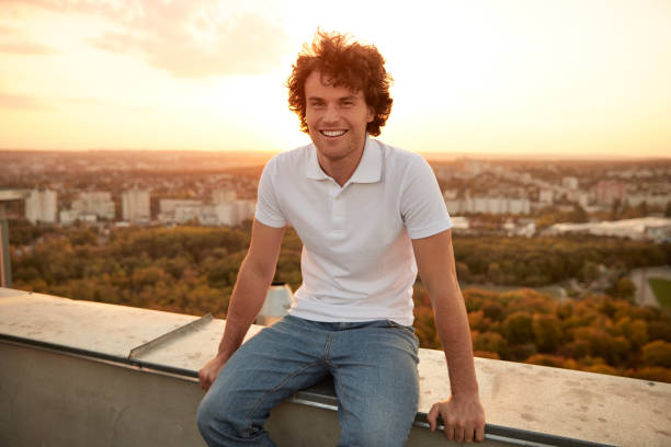 istock Happy man resting on rooftop during sunset 1303647760