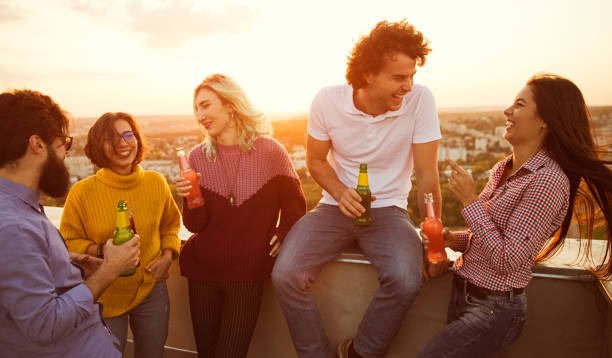 istock Young friends chatting during party on rooftop 1303647768