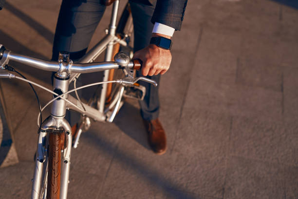 istock Crop businessman sitting on bicycle on sidewalk 1303647824
