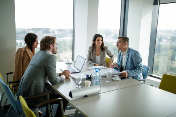 istock Senior manager explaining project on spreadsheet to his younger colleagues at conference table 1303648141