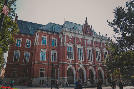 Krakow, Poland - October, 2015: The Jagiellonian University facade. The oldest university in Poland, the second oldest university in Central Europe. Main building - Collegium Novum with students.