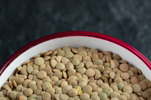 istock A red plate with unprepared lentils in a dark background 1303650796