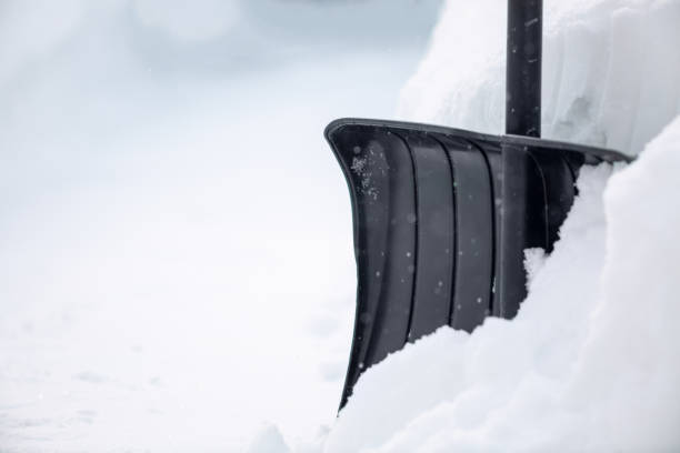 istock Snow cleaning concept. Black shovel in snow after snowfall 1303651891