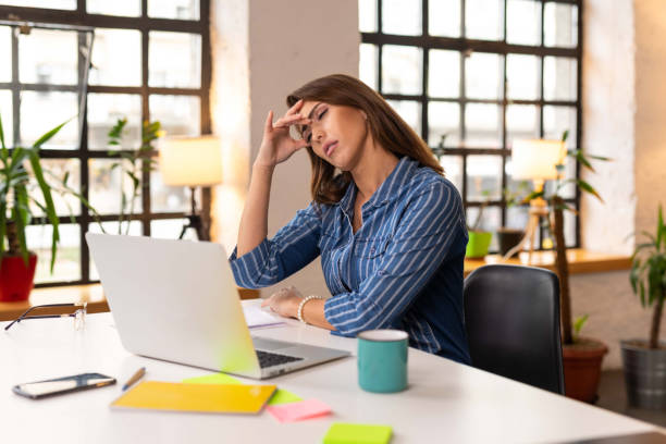 istock Exhausted businesswoman having a headache in the office 1303652921