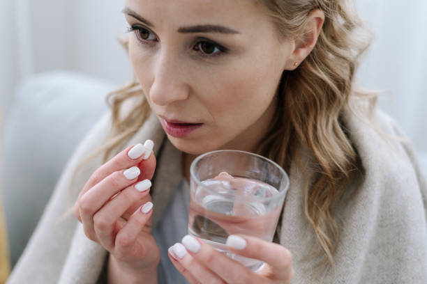 istock Ill woman covered with plaid take white pill 1303652961