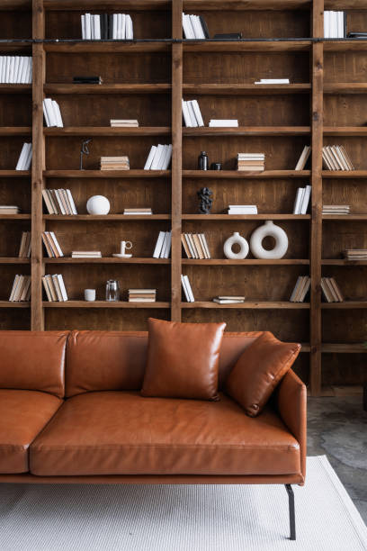 istock Room with comfortable couch and books on bookshelves 1303653006